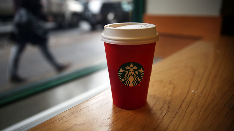 Red Starbucks cup on wood table