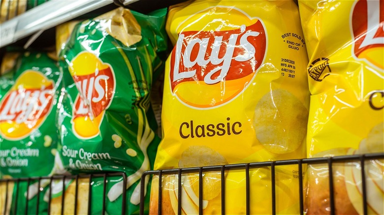Original and Sour Cream and Onion Lay's potato chips on a shelf.