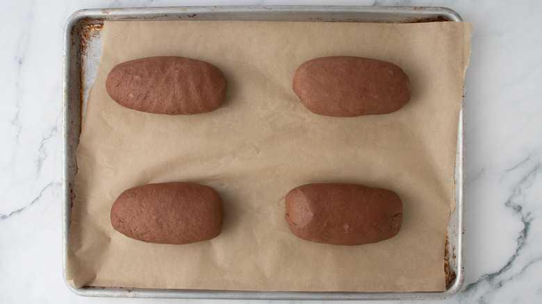 Brown bread loaves on baking sheet