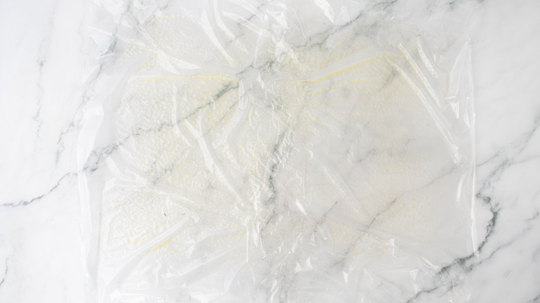 Greased plastic wrap on countertop