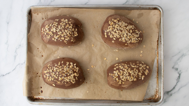 Brown bread loaves on baking sheet