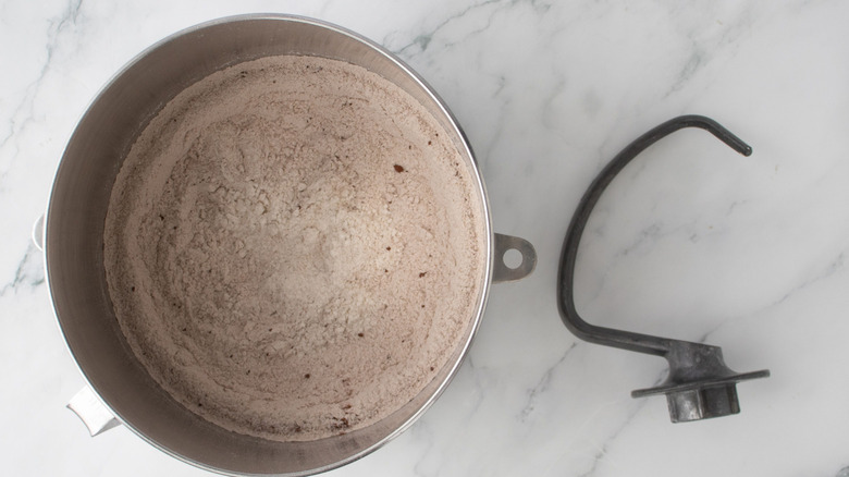 Flour mixture combined in bowl next to dough hook attachment