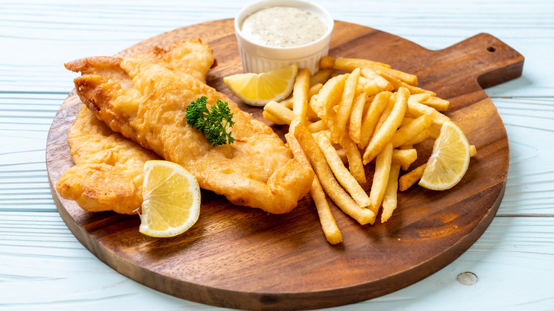 Fried fish and chips on wooden board