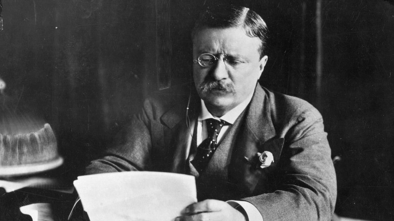 Theodore Roosevelt sitting at his desk