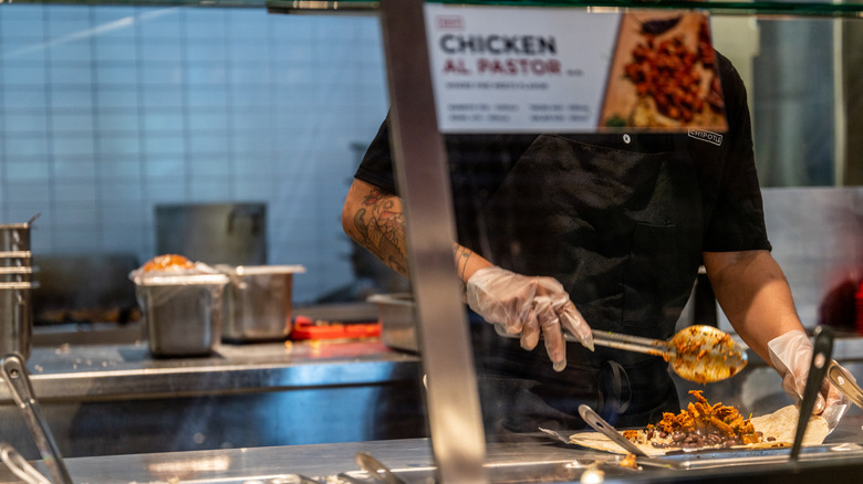 chipotle worker scooping meat