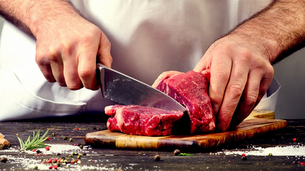 man slicing up steak