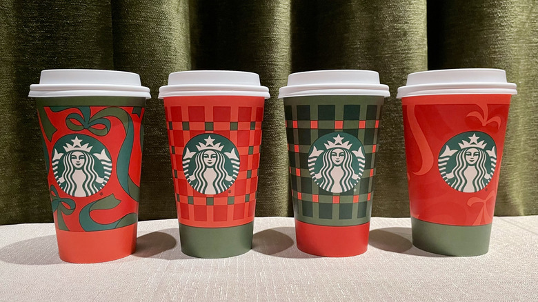 A lineup of the new red and green 2025 holiday season coffee cups at Starbucks