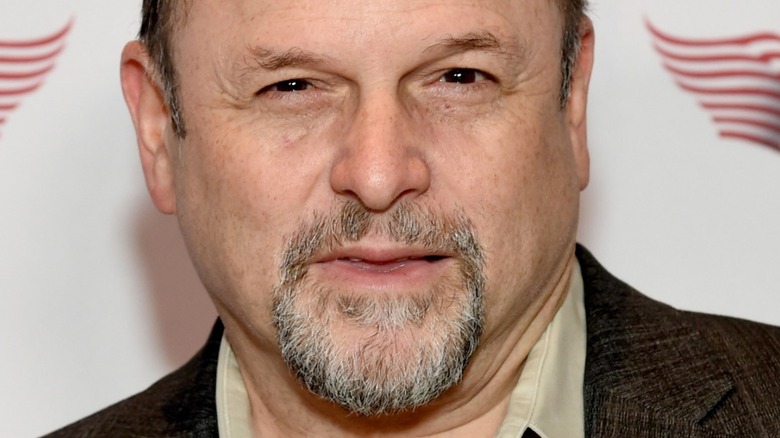 Close-up of Jason Alexander with slight squint and smirk