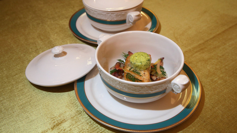 A tureen of gourmet food on a gold tablecloth at the White House.
