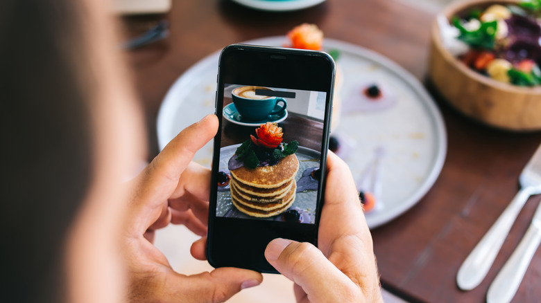 Person taking a picture of pancakes on their phone