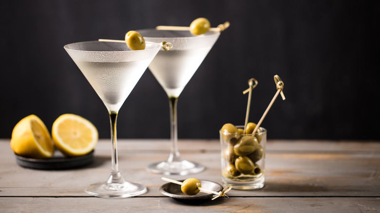 two chilled martinis in glasses with olive and lemon