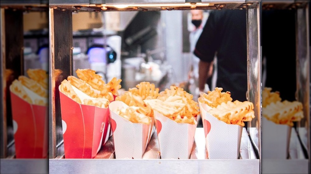 Chick-fil-A waffle fries wait under heat lamp