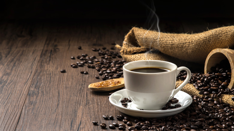 Coffee beans and mug on table