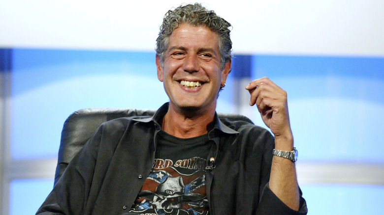 A picture of Anthony Bourdain sitting and smiling