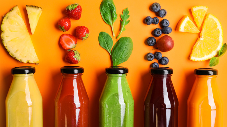 Line of fruits and juices in bottles