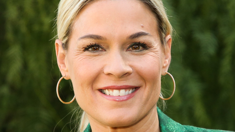 Cat Cora smiling with hoop earnings 