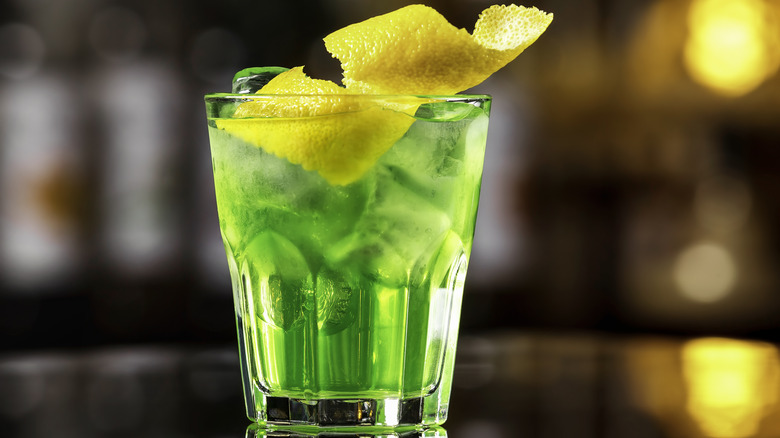 green cocktail with lemon twist