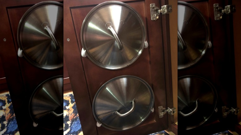 pot lids hanging on adhesive hooks attached to a cabinet door