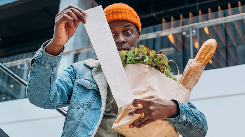 Shopper's eyes bugging at a grocery receipt