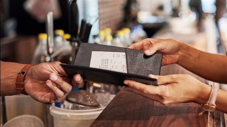 Waiter presenting restaurant bill 