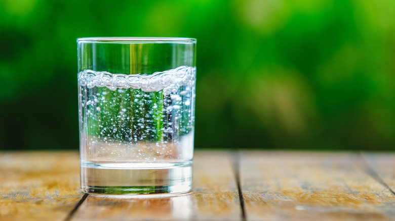 Glass of sparkling water on wooden table