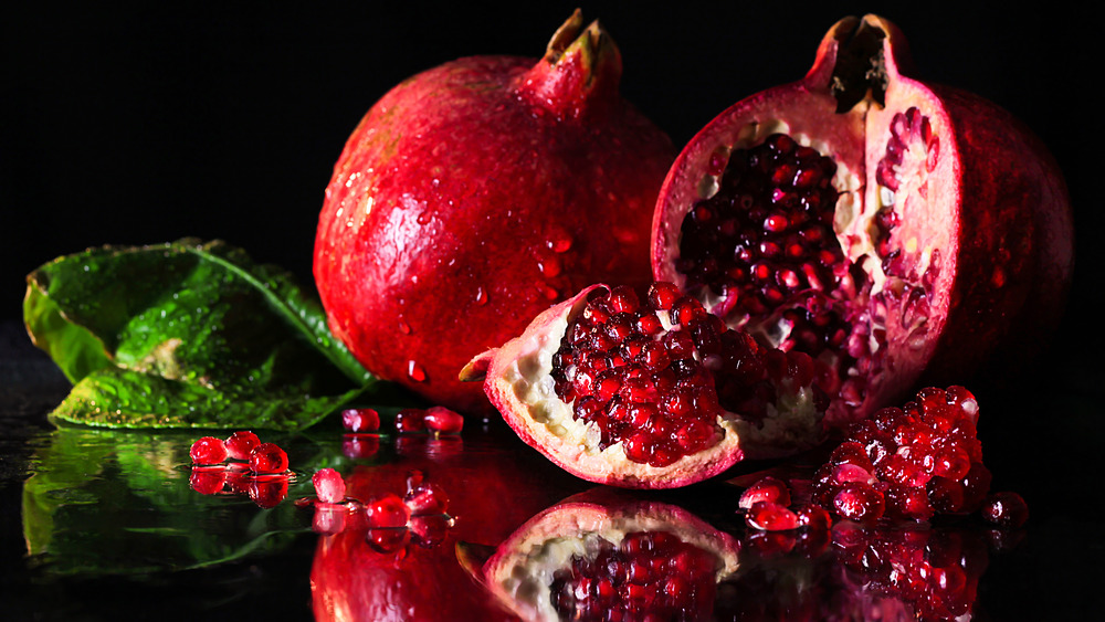 Open pomegranate on a black surface 