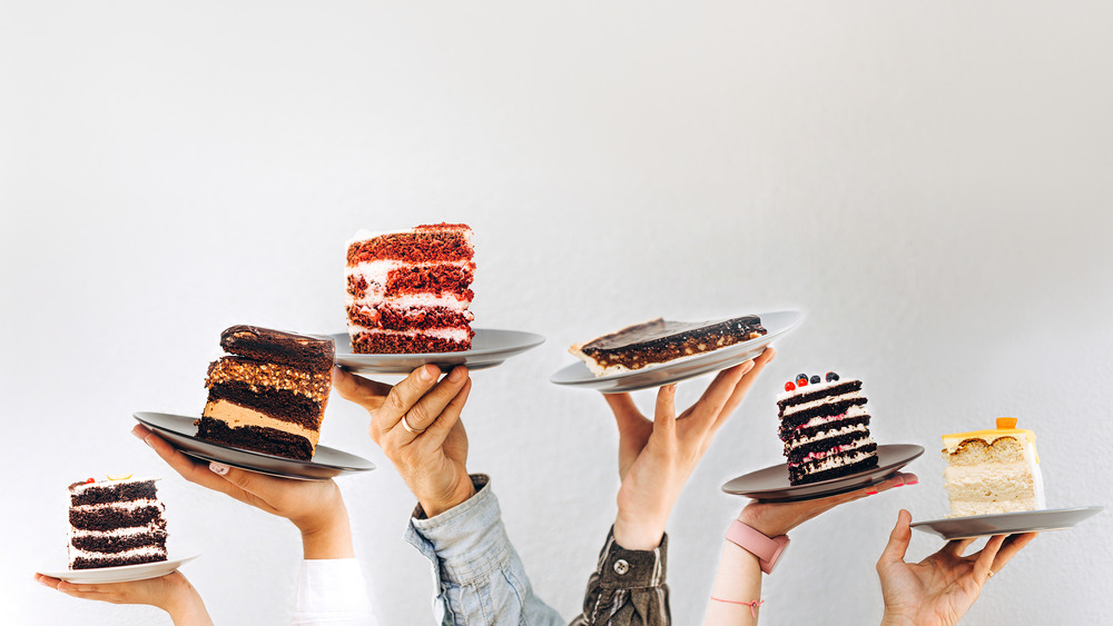 Hands holding different slices of cake on plates
