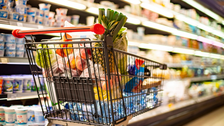 Groceries in cart in supermarket aisle