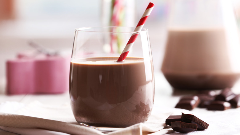 Glass of chocolate milk with red-and-white straw