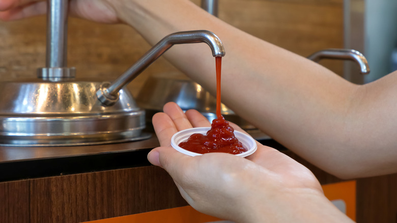 Using dispenser to put sauce into cup
