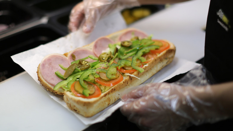 Employee holding open subway sandwich
