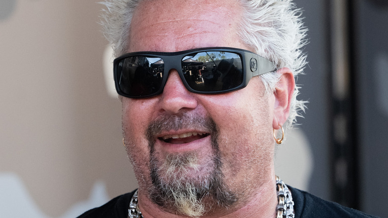 Guy Fieri smiling in sunglasses