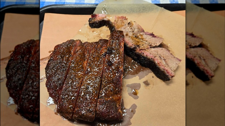 Slices of smoked brisket with a dark crust on brown butcher paper