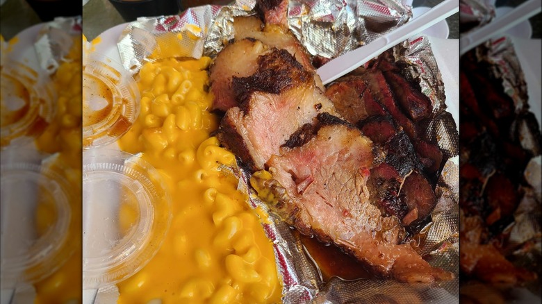 A container of sliced brisket and mac and cheese