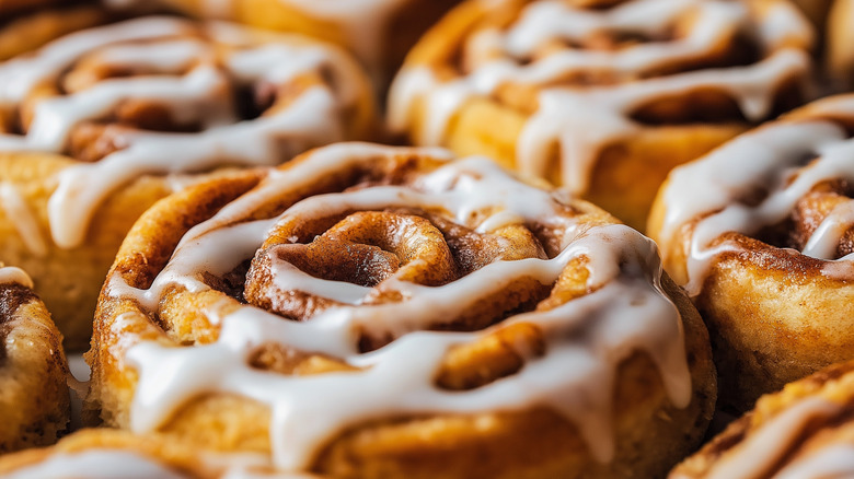 Close up of cinnamon rolls drizzled with frosting