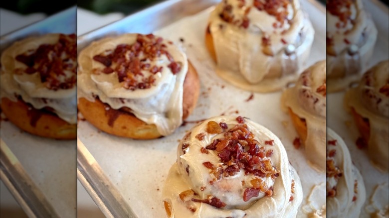 Cinnamon rolls topped with pieces of maple bacon from Agape Cakes