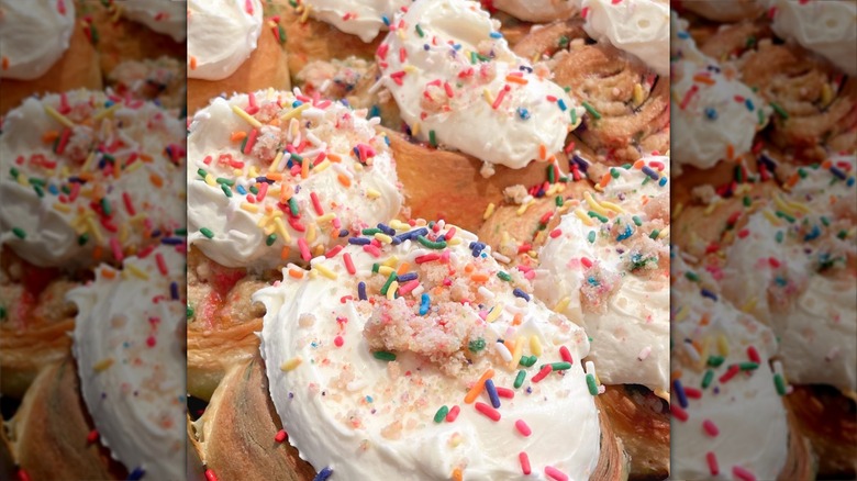 Cinnamon rolls topped with frosting and colorful birthday sprinkles