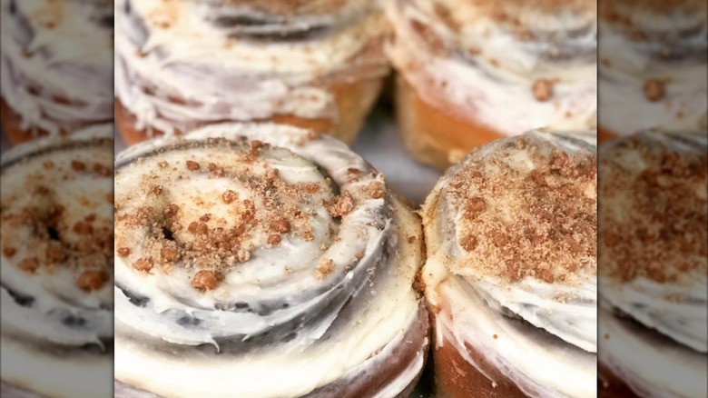 Cinnamon rolls topped with frosting and crumbs