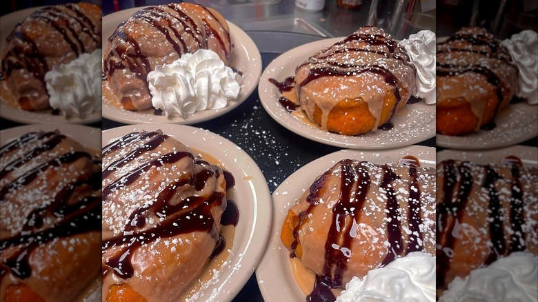 Cinnamon rolls drizzled with chocolate, served with whipped cream
