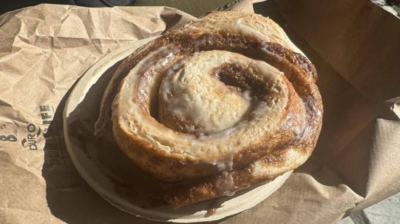 Frosted cinnamon roll with brown sugar on a plate