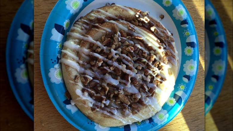 Montana Gold Bread Co cinnamon roll with nuts and stripes of frosting