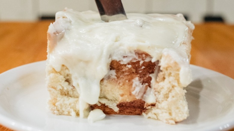 Large square cinnamon roll with a knife in the middle
