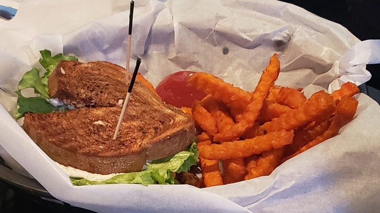 Salmon sandwich with sweet potato fries on the side
