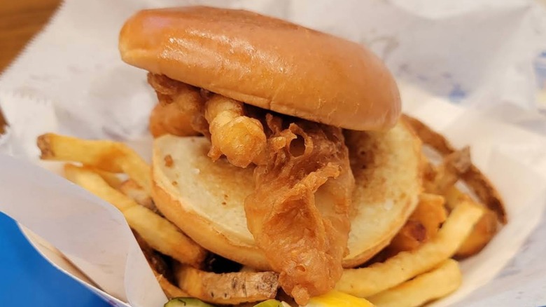 close up of fried fish sandwich at Mac's on french fries in basket