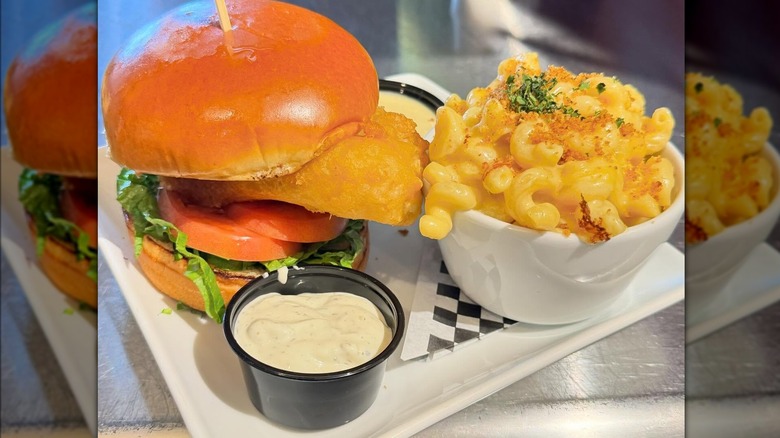 fish sandwich on bun served with side of macaroni and cheese