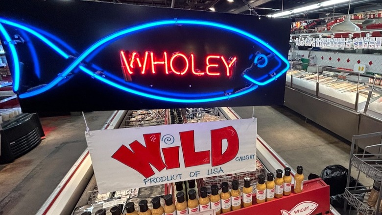 Neon fish market sign at Wholey's Fish market in Pennsylvania over coolers of frozen fish and near counters of fresh fish