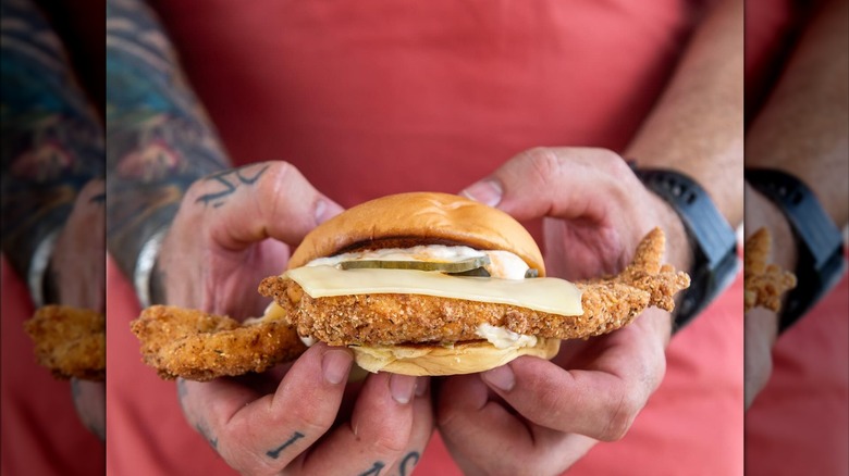 Fried fish sandwich on bun with cheese, pickle, and tartar sauce