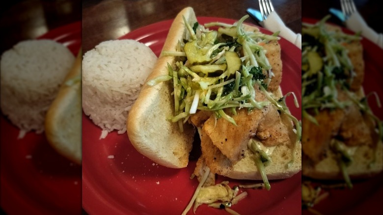 Walleye po'boy with slaw and sauce on plate with rice pilaf