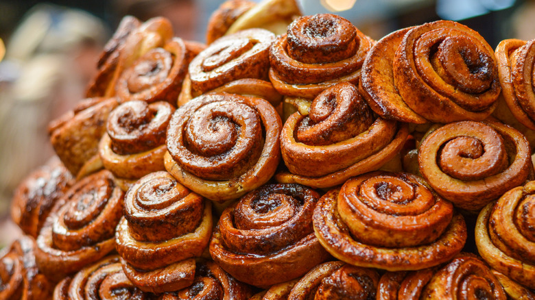 A bunch of cinnamon rolls piled up at the display section