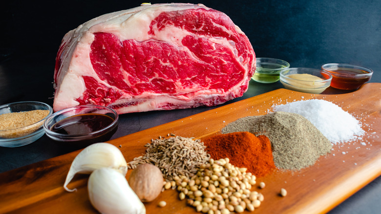 Raw prime rib with a variety of seasonings to make a rub
